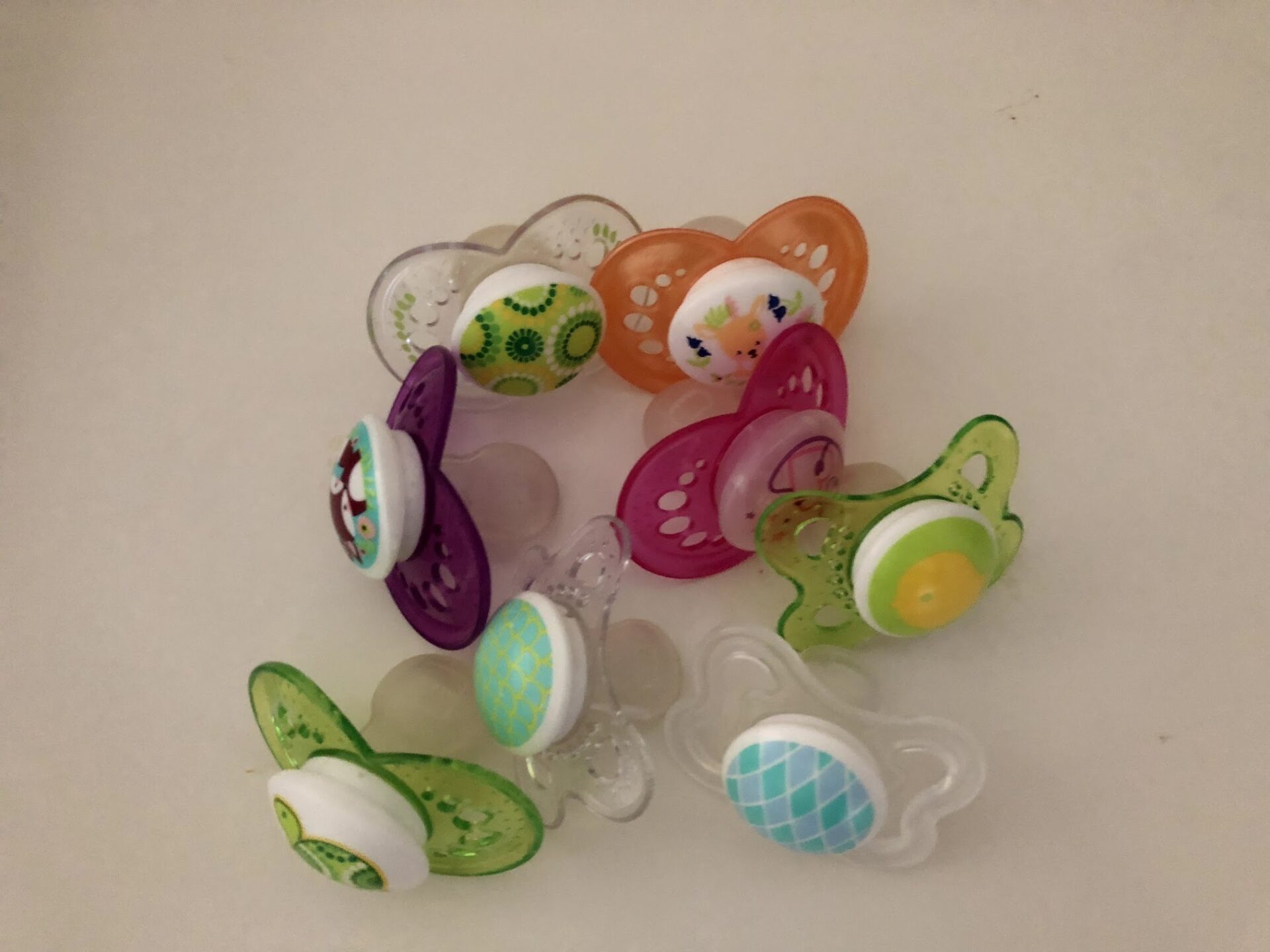 7 pacifiers in a variety of colors