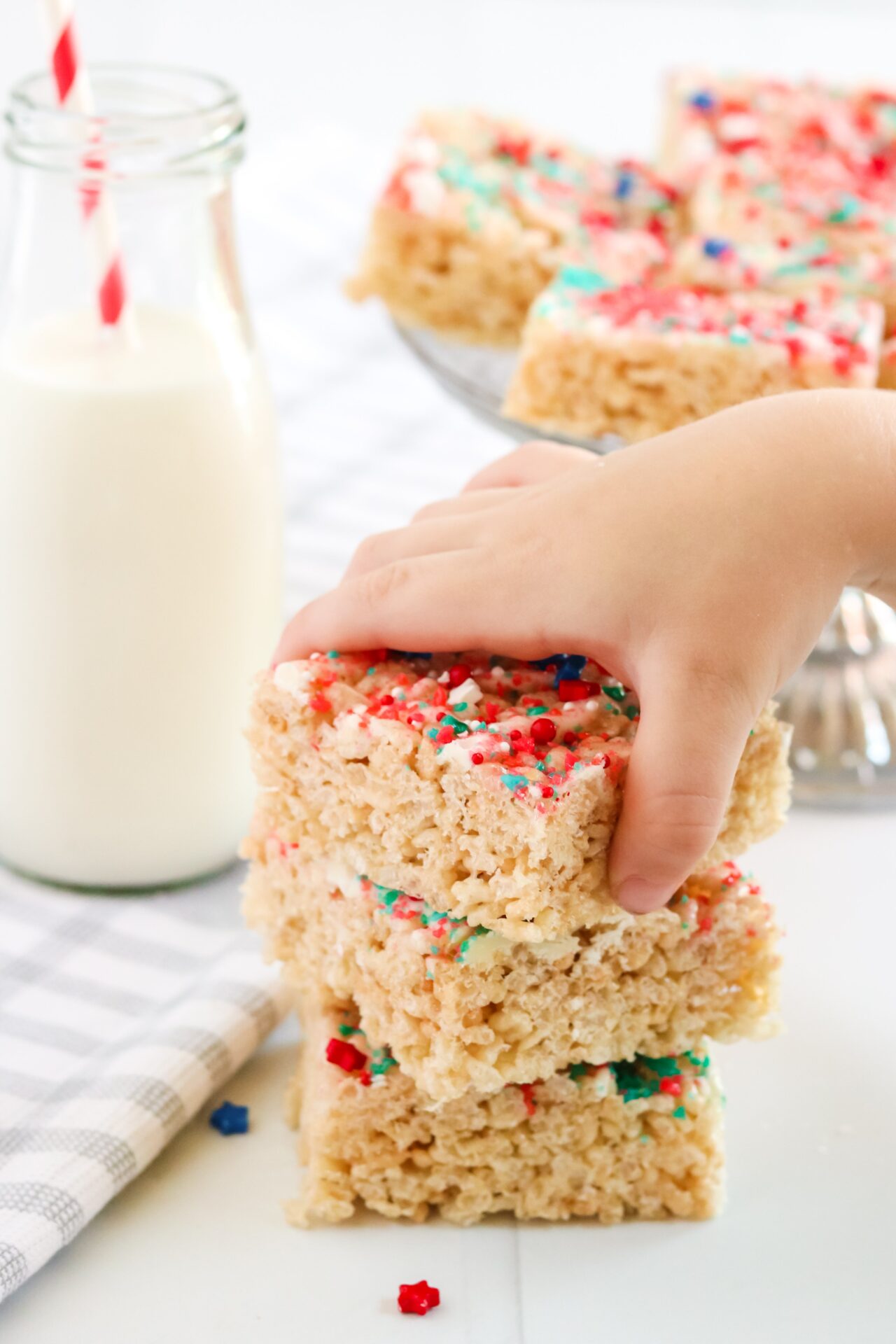 3 4th of July Rice Krispie Treat stacked with hand grabbing it. 