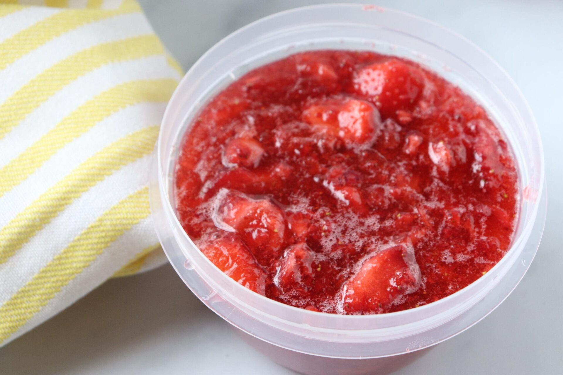 strawberry freezer jam in a plastic container. 