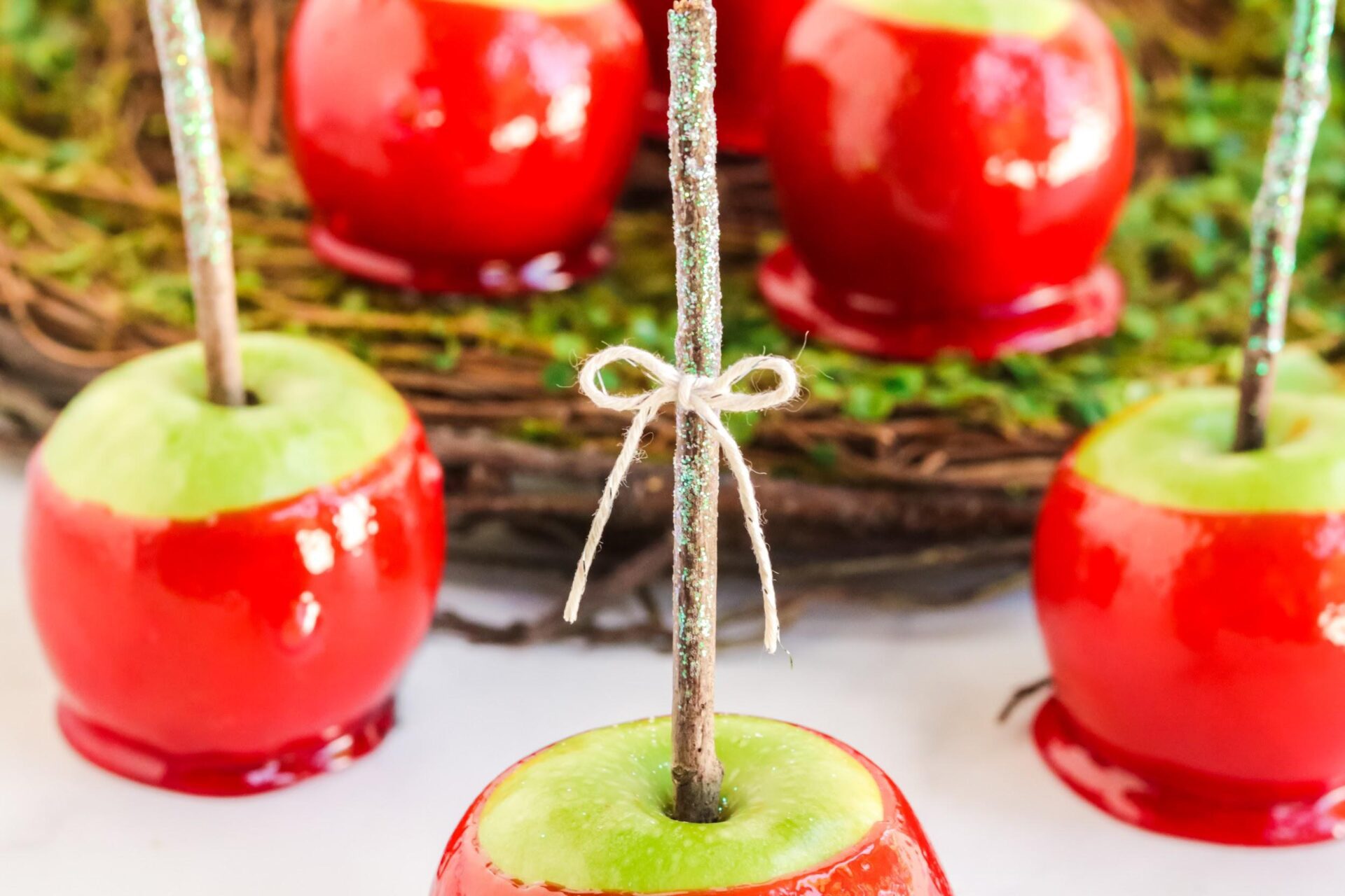 5 red candy apples on white counter