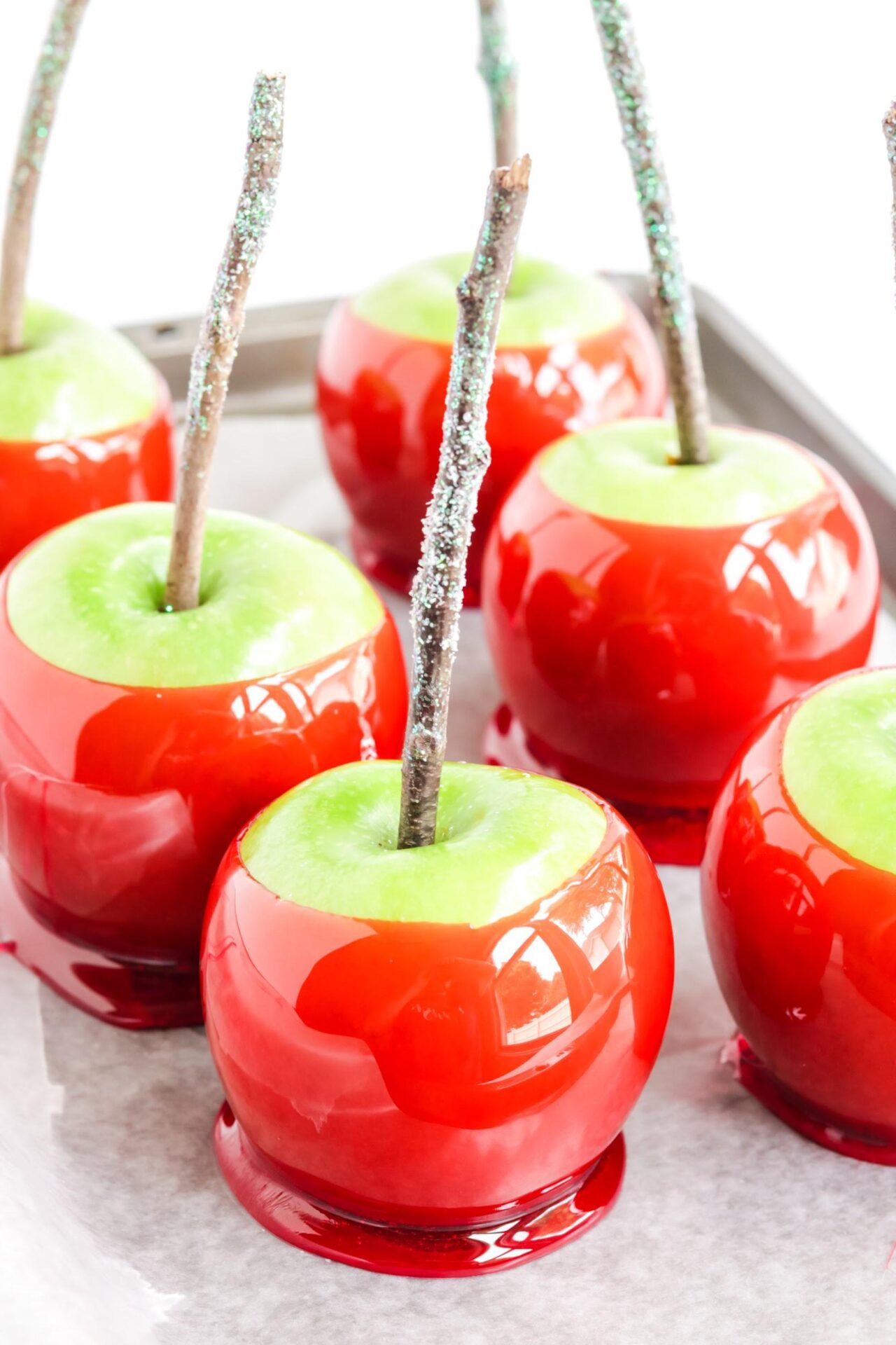 6 red candy apples on cookie sheet