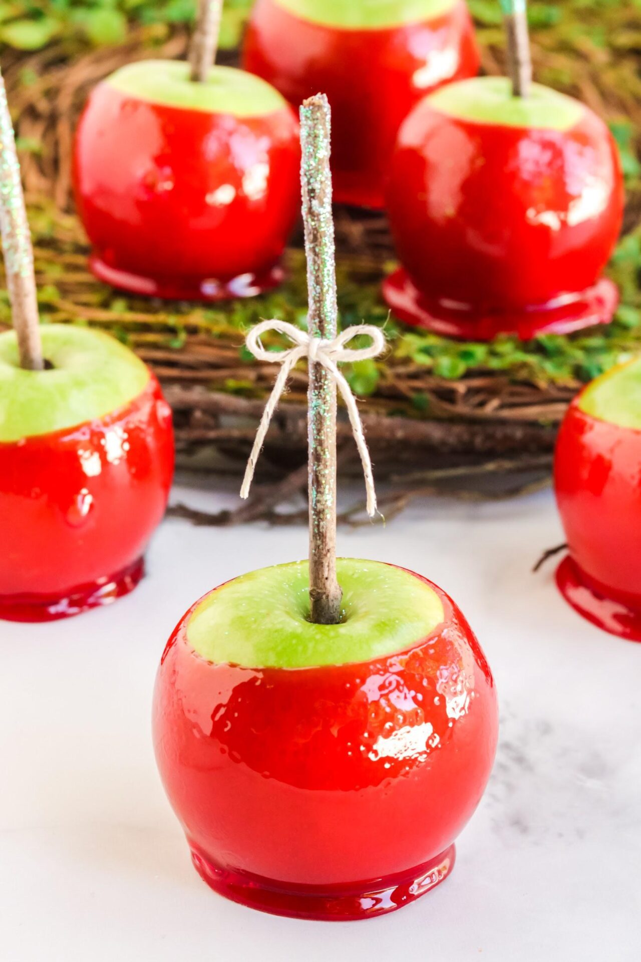 closeup of one red candy apples with 5 more in the background