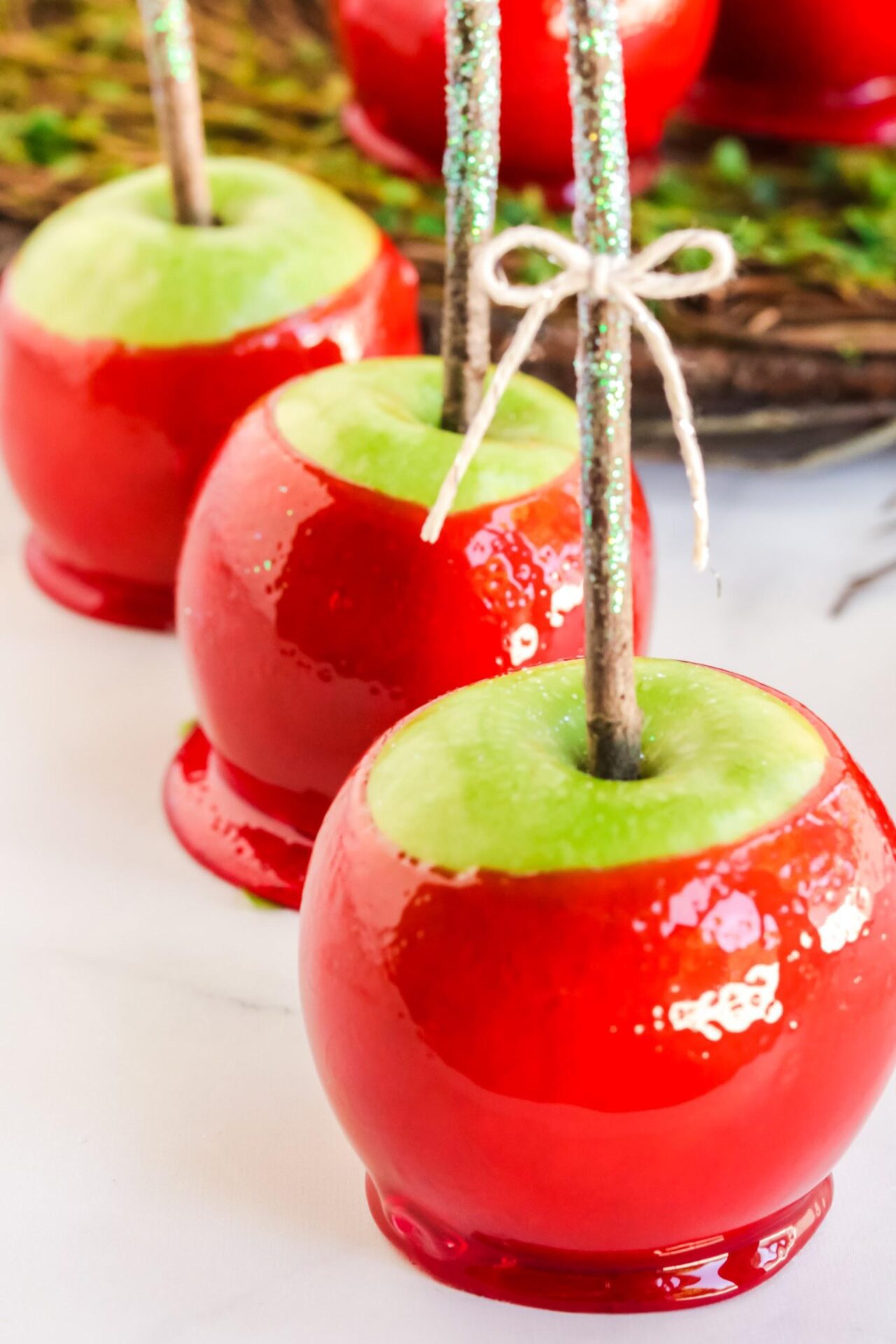 3 red candy apples tied with a bow