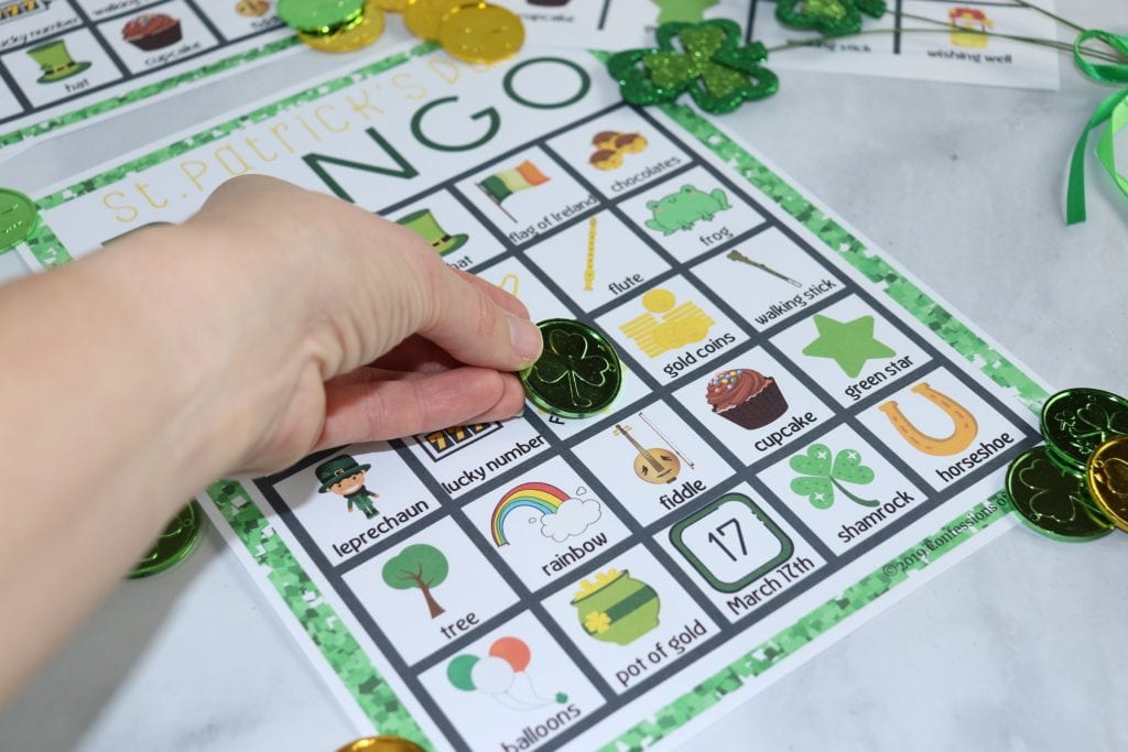 St. Patrick's Day Bingo sheet with a hand placing a play coin on the free space