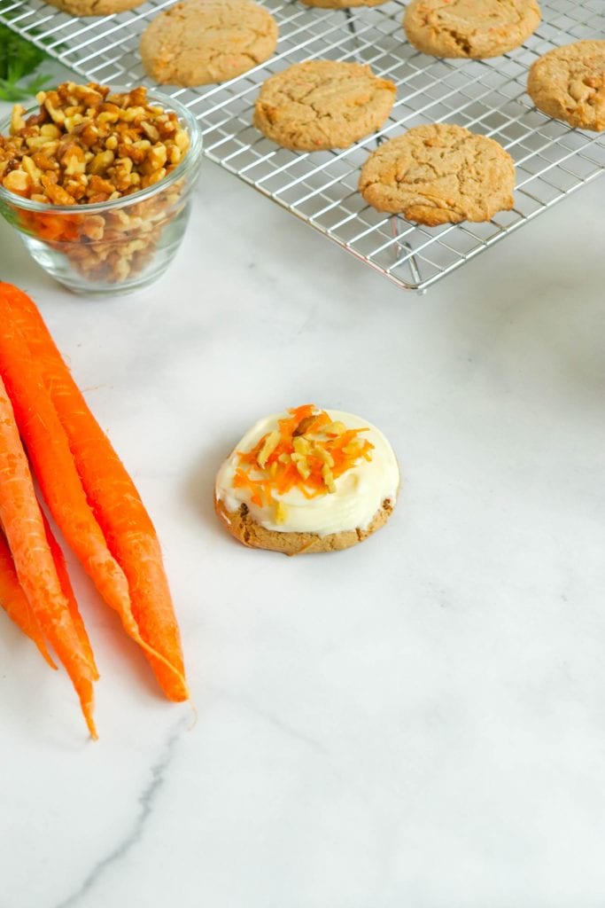 carrot cake mix cookies on cooling rack with walnuts in bowl and fresh carrots on the side