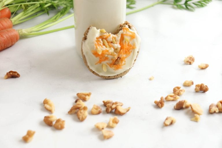bite taken out of carrot cake mix cookies standing against milk jug