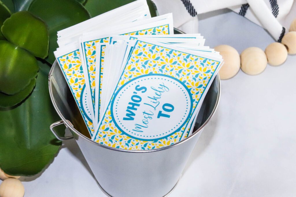 Printable Who’s Most Likely To family game cards displayed in a bucket for screen-free group fun