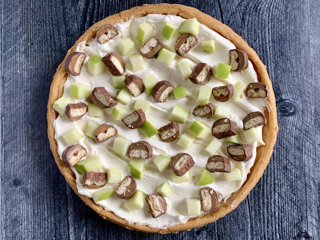 apple dessert pizza with sauce, apple, and Twix