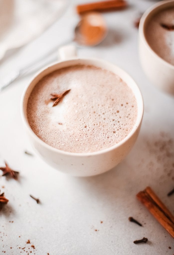 pumpkin spice hot chocolate with spices around the mug