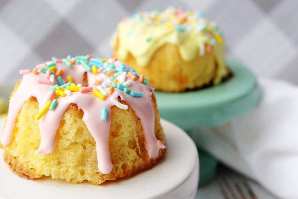 close up of mini bundt cakes with pink icing drips and sprinkles