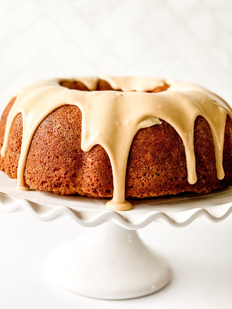 buttermilk pound cake with drizzle on a white cake stand