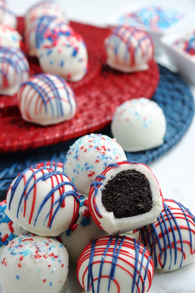 bite take from Oreo truffles sitting on red and blue platters