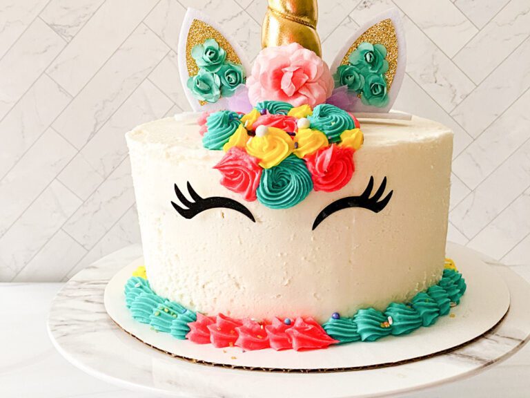 rainbow unicorn cake on a marble cake stand