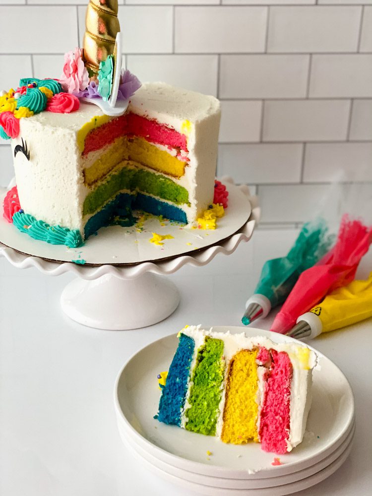 slice of rainbow cake cut from a unicorn cake