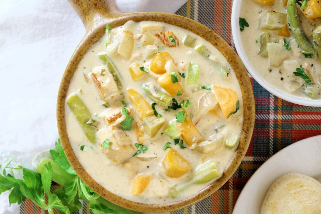 chicken pot pie soup in a speckled brown soup bowl