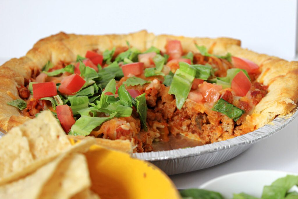 taco bake in a pie pan with slice removed
