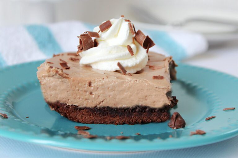 brownie french silk pie recipe on a blue plate with whipped cream and chocolate