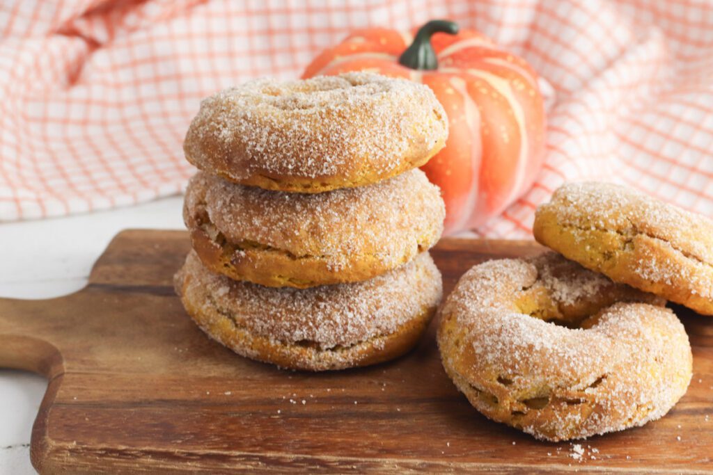 pumpkin donuts on a cutting board with fall decorations