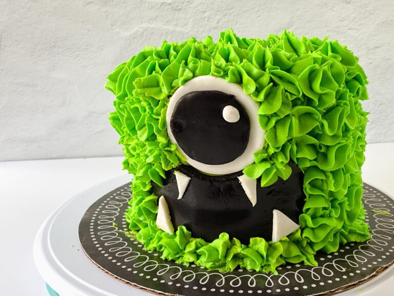 green monster cake with buttercream and fondant decorations