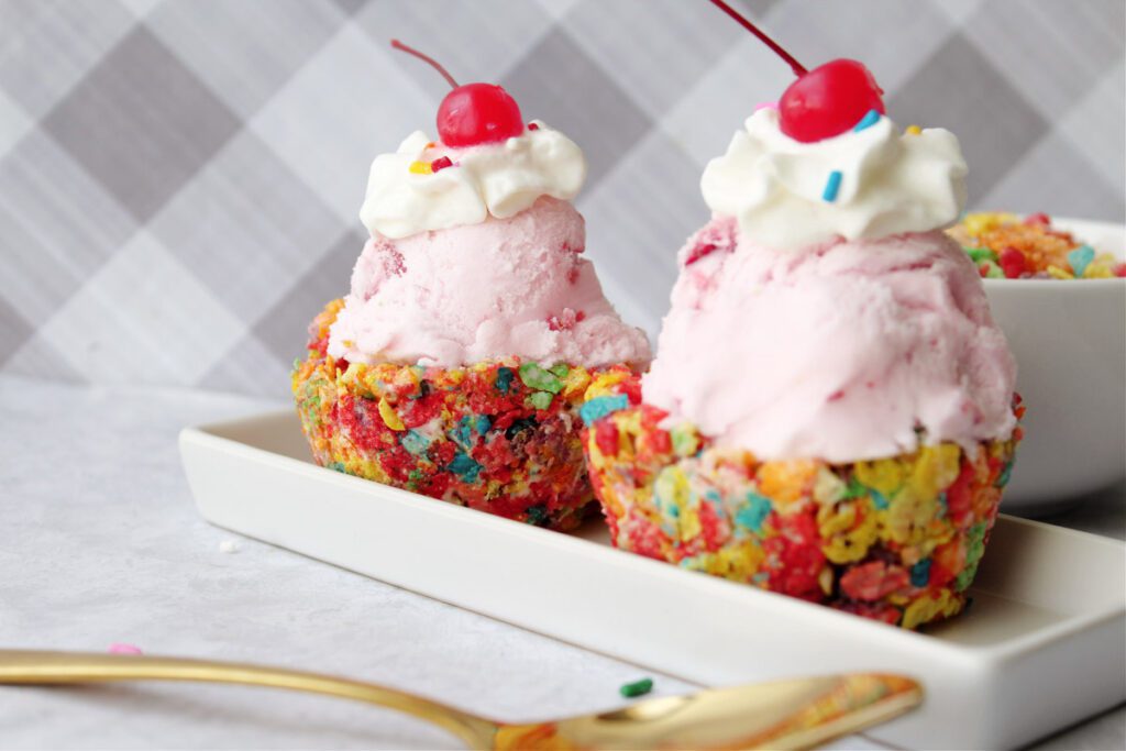 rainbow cereal ice cream cups with strawberry ice cream inside on white dish. 