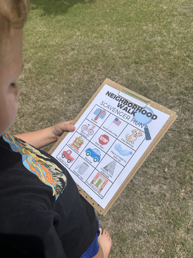 closeup of boy holding clipboard outside with neighborhood walk scavenger hunt