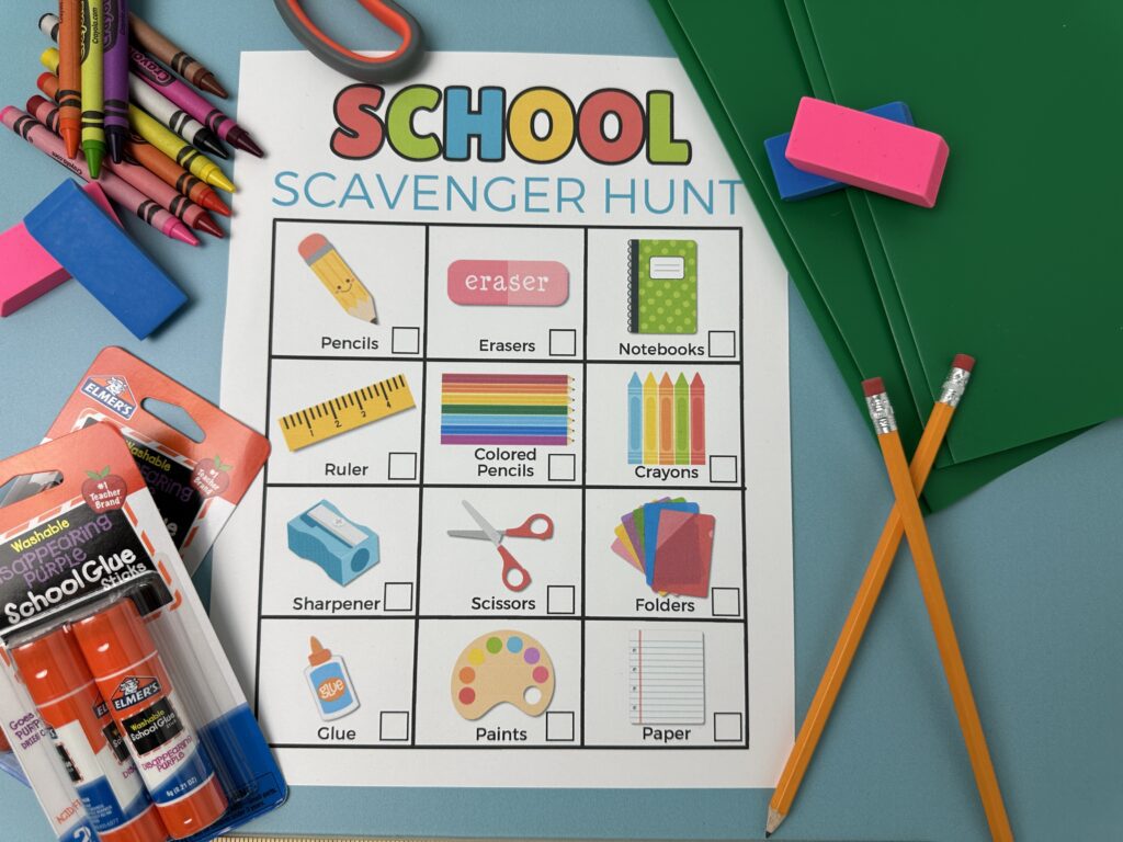 Close-up shot of the school scavenger hunt printable showing items like crayons, glue, folders, and colored pencils with part of the black-and-white version underneath.
