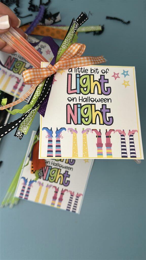 Set of Halloween light sticks tied with colorful ribbons next to glow bracelets.