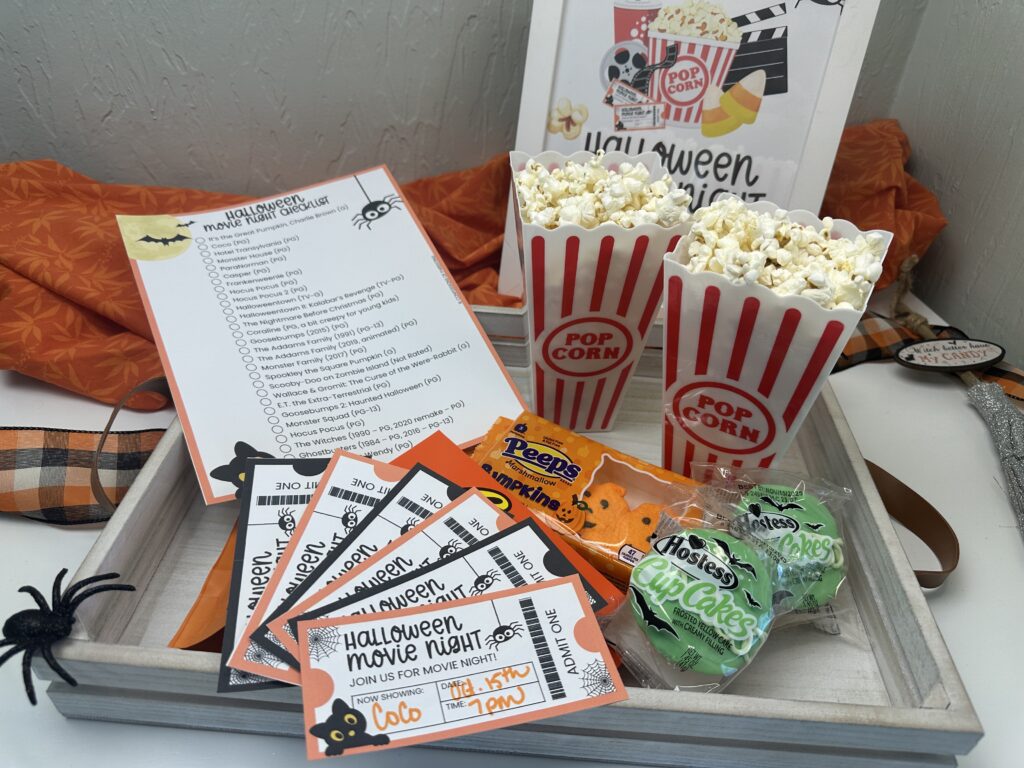 Halloween movie night display with checklist, popcorn, candy, and tickets ready for a family movie night.