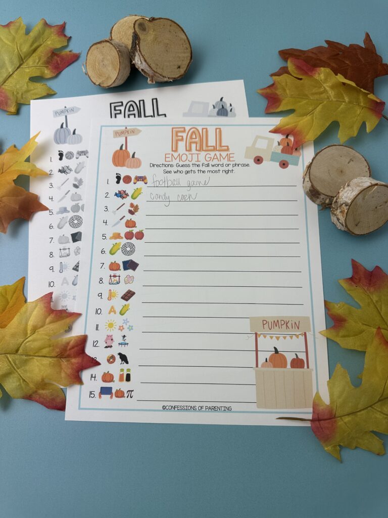 Two lines Completed Fall Emoji Game sheet with answers written in, surrounded by colorful fall leaves and wooden log pieces.