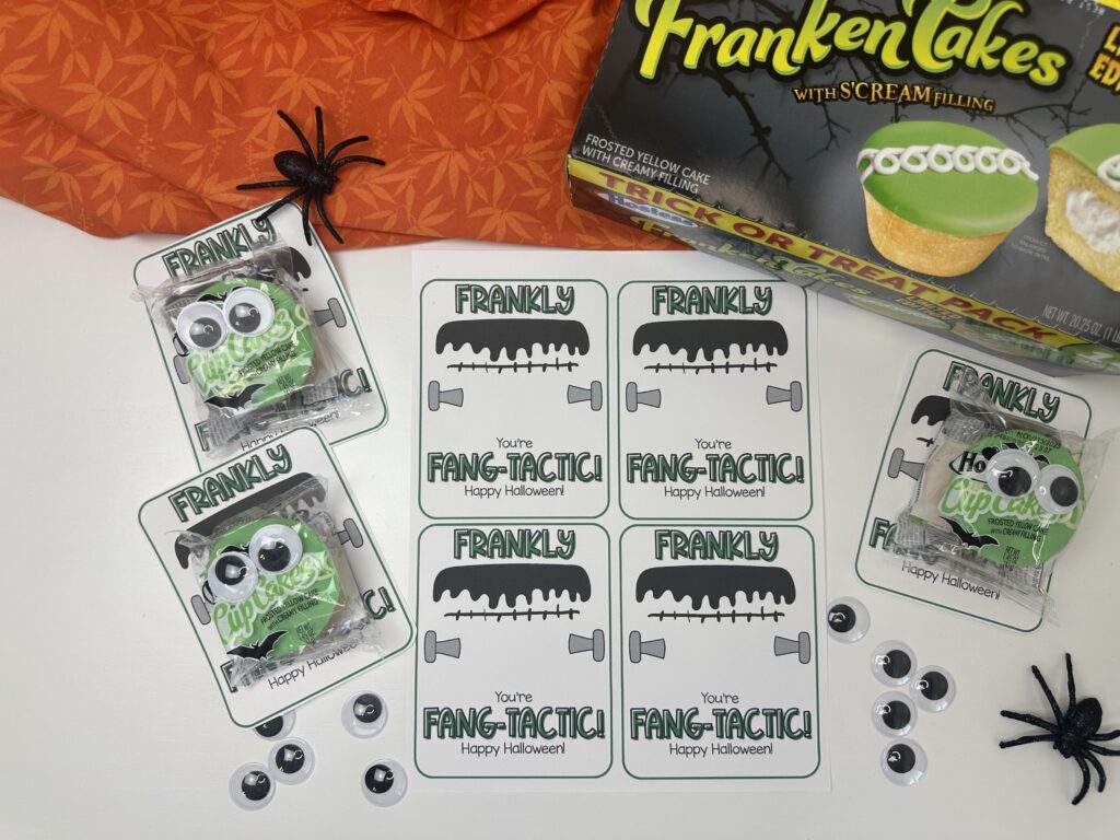 Overhead view of “Frankly You’re Fang-tastic” cupcakes with googly eyes and Halloween spiders for festive gifts.