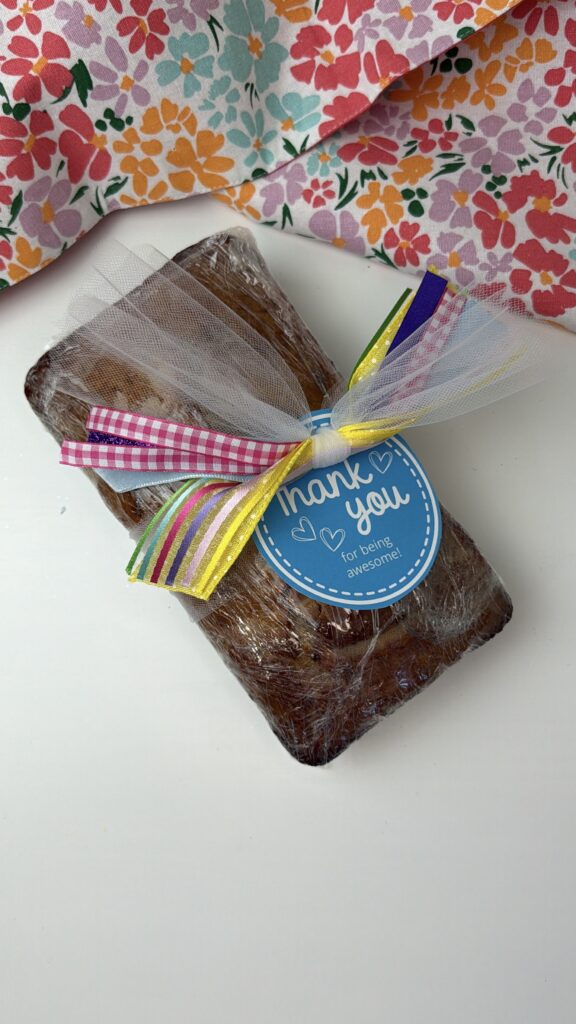 Homemade bread wrapped in plastic with a colorful ribbon and a blue “Thank you for being awesome” gift tag attached.
