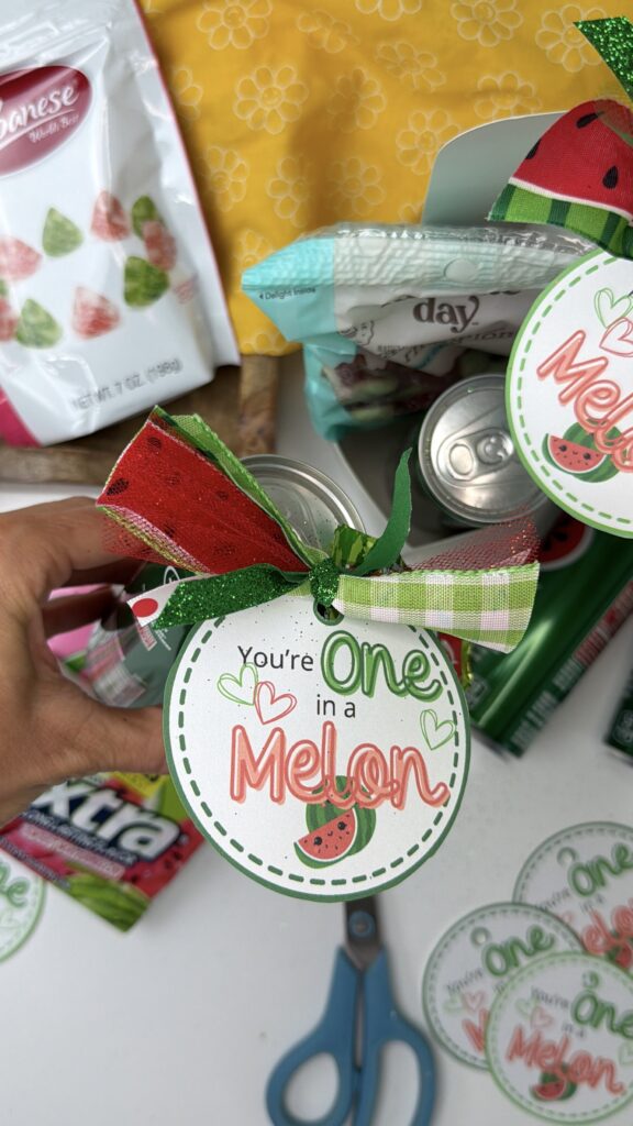 Close up of you’re one in a melon printable gift tag with watermelon soda cans and summer treats

